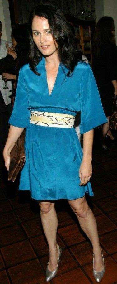 A Woman In A Blue Dress Standing On A Tile Floor