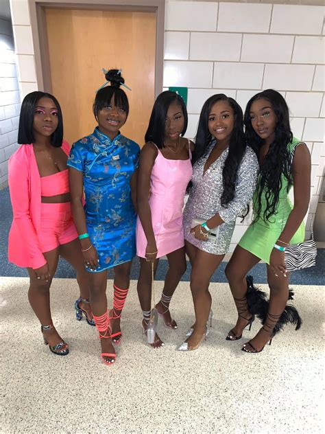 Four Women In Short Dresses Posing For The Camera