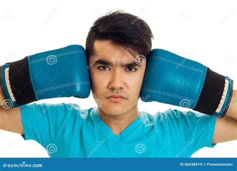 A Young Black Haired Guy Has His Hands In Boxing Gloves Near Face Close