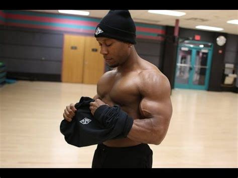 A Shirtless Man Holding His Jacket In An Empty Gym