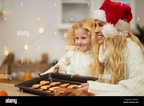 Side View Of Blonde Woman Wearing Christmas Hat Baking Cookies With