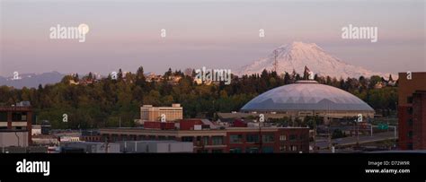 A Full Moon Appears On The Horizon Near Mt Rainier And The Tacoma Dome