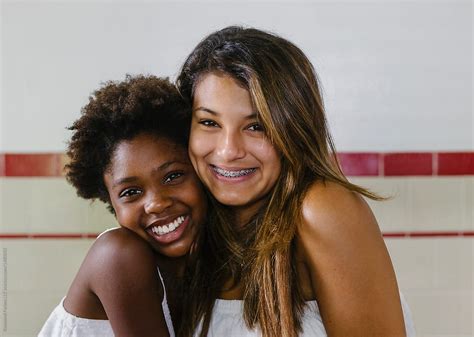 Beautiful Hispanic And African American Sisters With Braces On Teeth