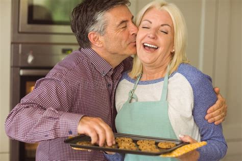Mature Blonde Holding Fresh Cookies With Husband Kissing Her Stock Image Image Of Cookie