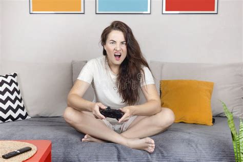 Brunette Woman Is Holding A Black Joystick Woman Emotionally Play Video Game On The Console
