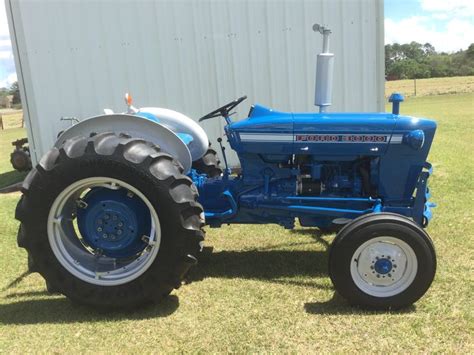 Blue Ford Tractor in Front of White Building