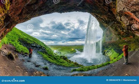 Natural Cave with Seljalandsfoss Waterfall Flowing and Tourist Enjoying ...