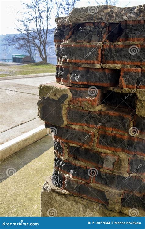 A Corner Of A Dilapidated Building With A Drainpipe And Battered Walls