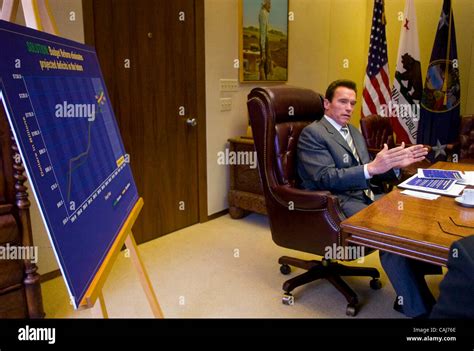 Governor Arnold Schwarzenegger works with staff members Wednesday Jan 9 ...