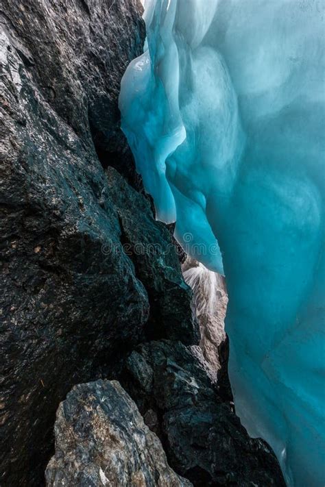 Beautiful Blue Ice Next To Water Flowing Over Large Stones. Stock Image ...
