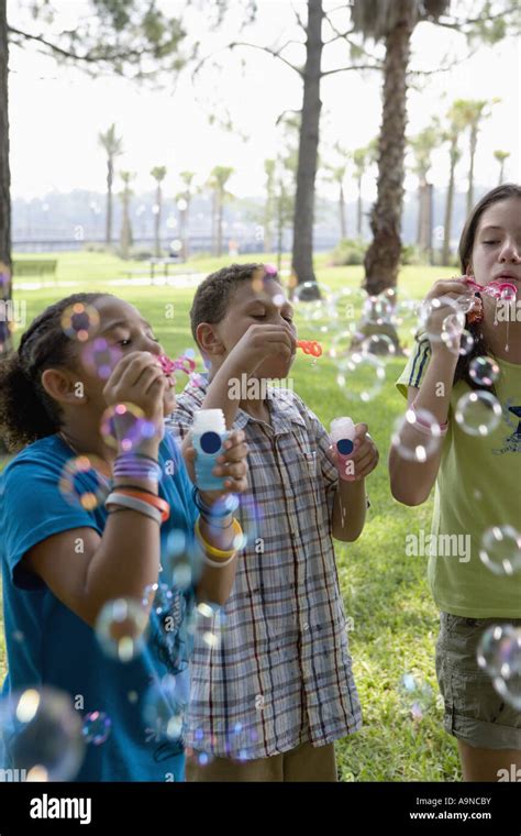 Children blowing bubbles at a park Stock Photo - Alamy