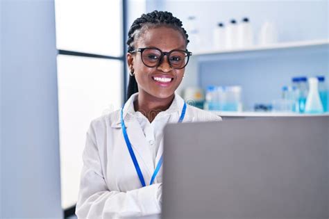 African American Woman Scientist Smiling Confident Using Laptop At