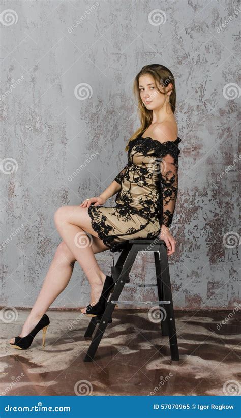 Belle Jeune Femme Blonde Aux Cheveux Longs Avec Un Chiffre Mince Dans Un Or Et Une Mini Robe