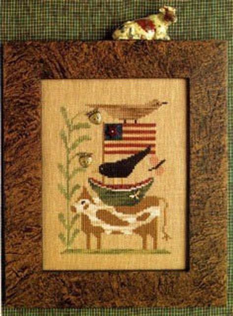 A Cross Stitch Picture With A Deer And An American Flag