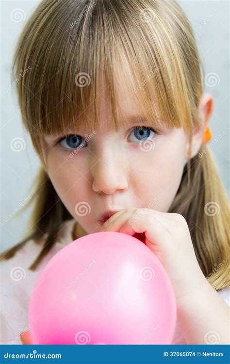 Petite Fille Mignonne Gonflant Un Ballon Rose Dans La Cuisine Photo