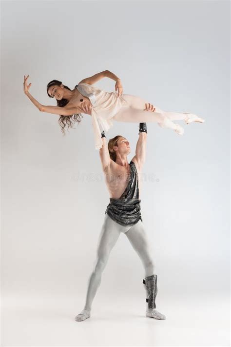 Young Couple of Ballet Dancers in Ancient Rome Costumes Dancing on White Studio Full of Light ...