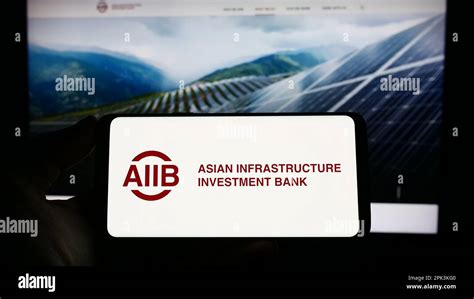 Person Holding Smartphone With Logo Of Asian Infrastructure Investment