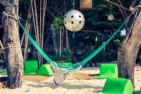 Hammock Hanging Under Exotic Tree On Beach With White Sand Below Stock