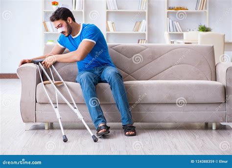 The Injured Man with Crutches Recovering at Home Stock Image - Image of injury, medicine: 124388359