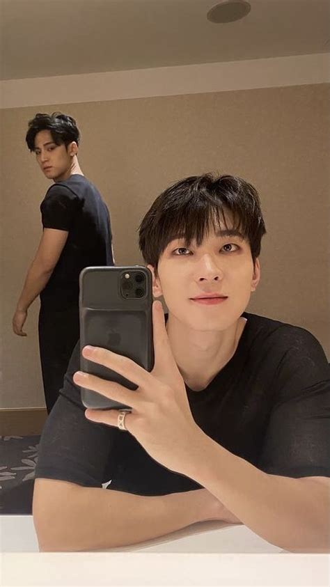 A Man Taking A Selfie With His Cell Phone In Front Of Him And Another