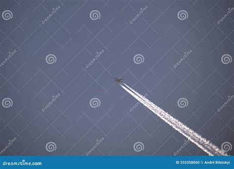 Distant Passenger Jet Plane Flying On High Altitude On Clear Blue Sky