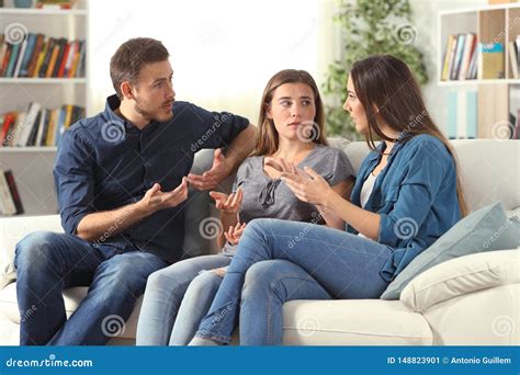 Three Serious Friends Talking Sitting On A Couch At Home Stock Image