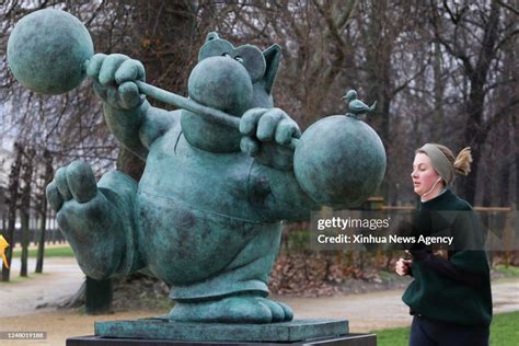 A woman passes by a sculpture of Le Chat at the Brussels Park in ...