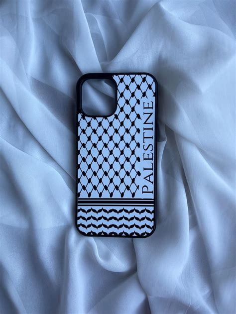 A Cell Phone Case Sitting On Top Of A White Bed Sheet With The Word