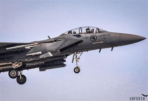 A Fighter Jet Flying In The Sky With Its Landing Gear Down And Four