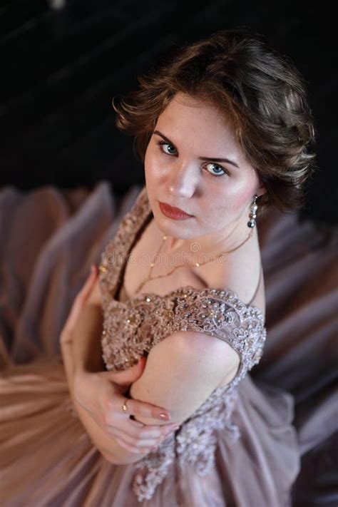 The Girl The Brunette In A Beautiful Dress Poses Sitting On A Floor Stock Photo Image Of