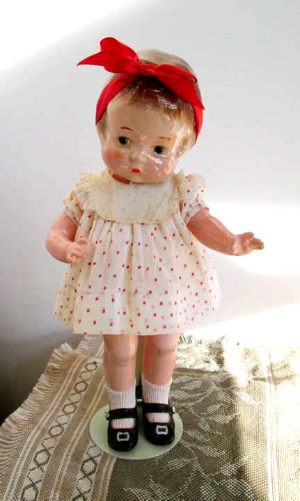 An Old Doll Is Standing On A Bed