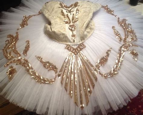 A White Tutu With Gold Sequins On It