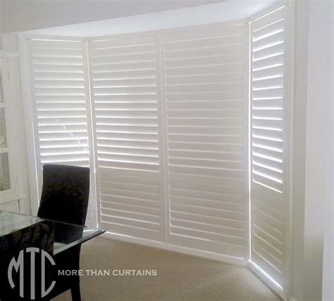 Painted hardwood plantation shutters on a bay window - More Than Curtains