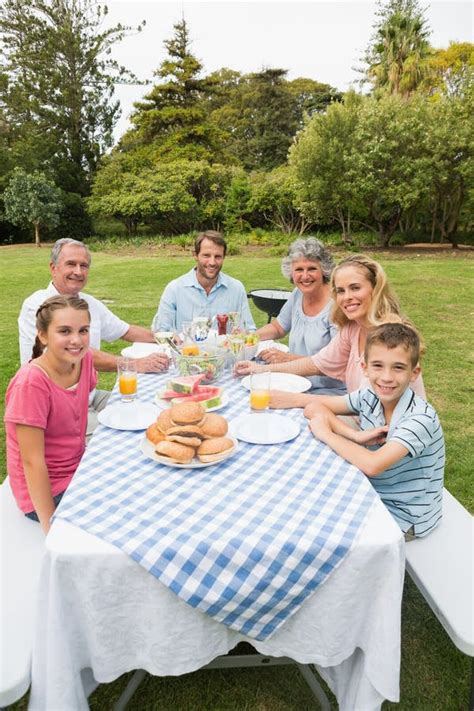 Familia Extensa Feliz Que Cena Al Aire Libre En La Mesa De Picnic Foto