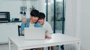 Joven Pareja Gay Bes Ndose Mientras Usa Computadora Port Til En Casa Moderna Los Hombres