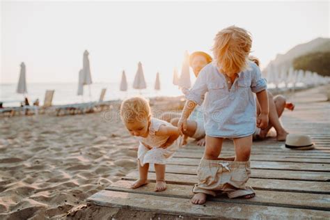 Una Familia Con Dos Ni Os Del Ni O Que Se Sientan En La Playa De La