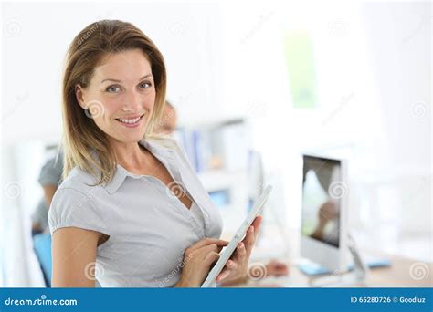 Femme D Affaires Blonde De Sourire L Aide Du Comprim Au Bureau Photo Stock Image Du Beau