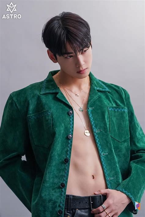 A Man With No Shirt Wearing A Green Jacket