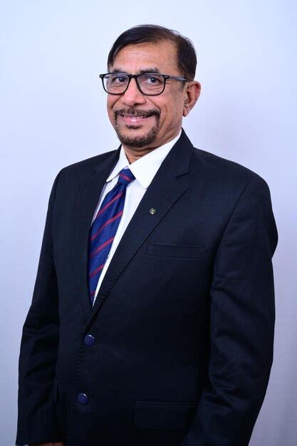 Premium Photo A Man In A Suit And Glasses Stands In Front Of A White