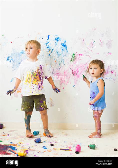 Children (2-3) painting on wall Stock Photo - Alamy