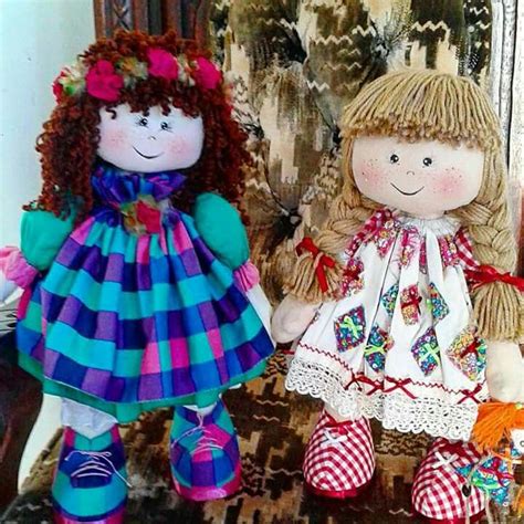 Two Dolls Sitting Next To Each Other On A Chair