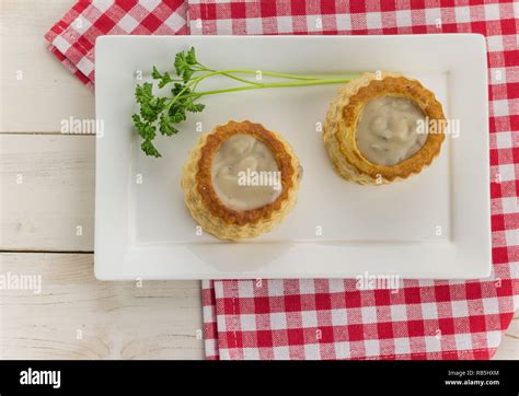 Puff pastry vol-au-vents filled with mushroom ragout on a wooden table ...