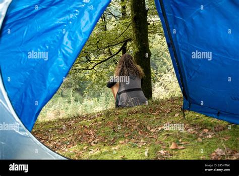 Forest Oasis A Serene Moment Of Reflection As A Brunette Woman Rests Outside Her Tent Stock
