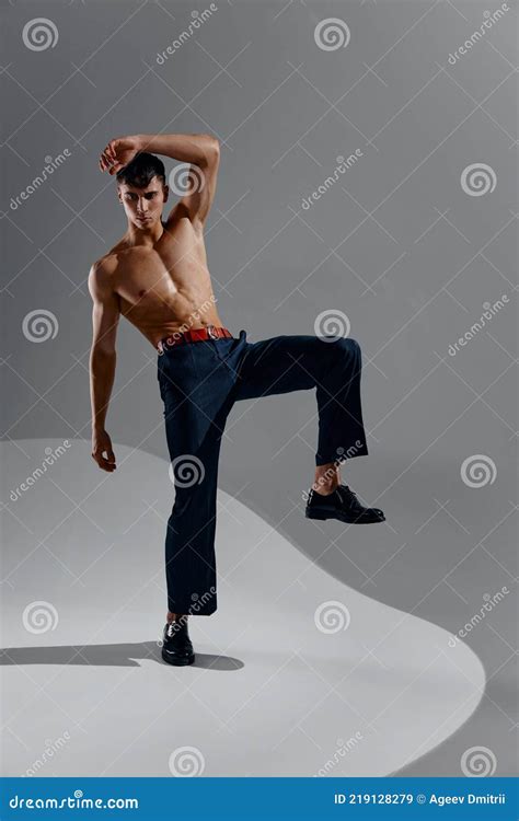 Man In Jeans Patent Shoes Lifted His Leg Up And Naked Torso Bodybuilder Fitness Stock Image