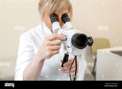 Blonde femme médecin gynécologue ressemble au moyen d un colposcope Examen par un gynécologue