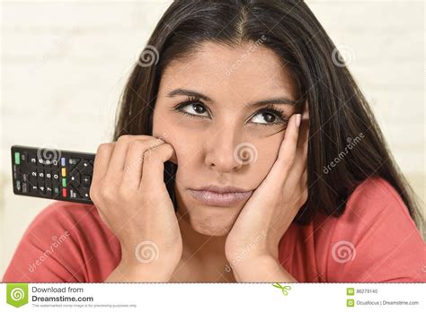 Young Beautiful Hispanic Woman At Home Watching Television Tired And