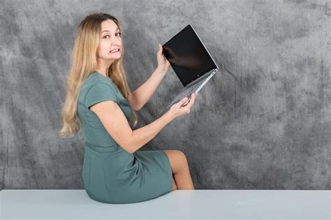 Premium Photo Woman With Beautiful Blonde Hair Sitting On A Table With A Laptop
