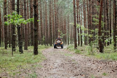 Homem que monta um veículo todo terreno amarelo de quadriciclo atv em