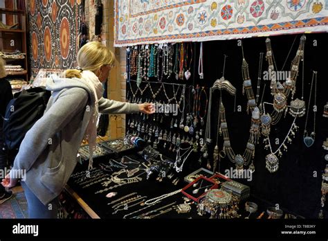 A tourist inspects traditional jewelry in a souvenir shop in Tashkent ...