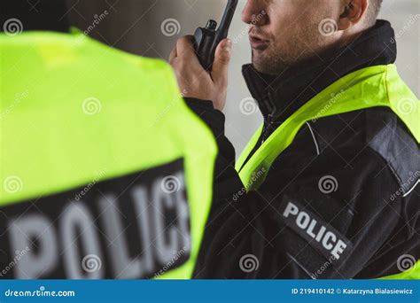 Policemen Speaking On The Walkie Talkie Reporting To Station Stock